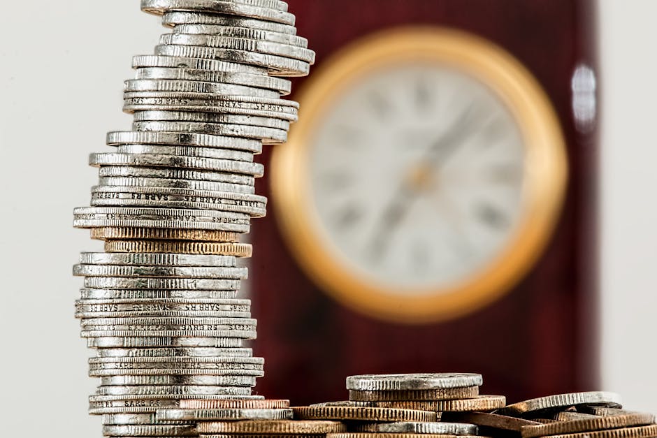 Stacked coins representing financial growth and investment with a blurred clock in the background